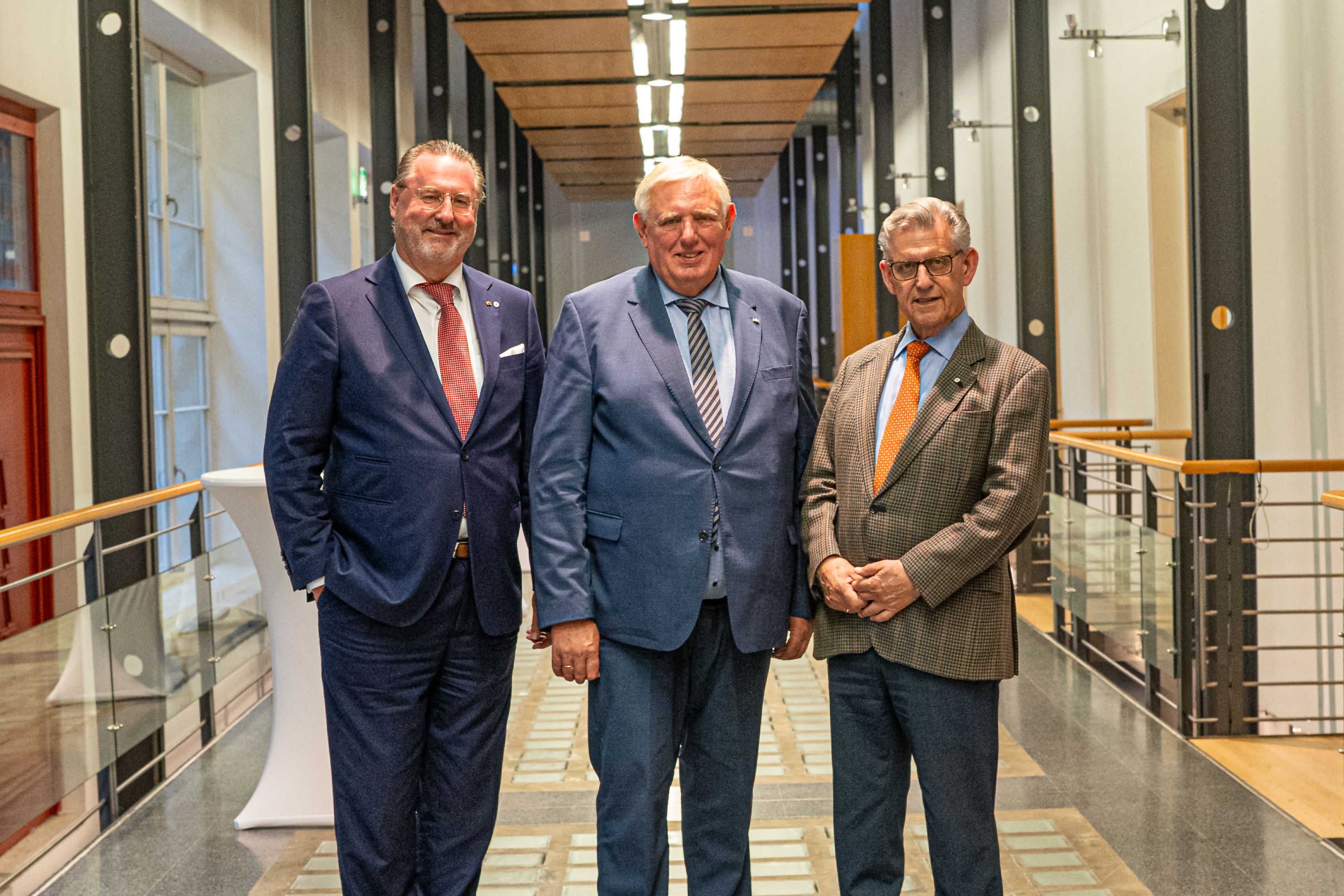 (von links) Dr. Alexander Schröder-Frerkes (Präsident DRK-Landesverband Nordrhein), Minister Karl-Josef Laumann und Dr. Fritz Baur (Präsident DRK-Landesverband Westfalen-Lippe) stehen beim Sommerempfang des DRK auf einem Gang.