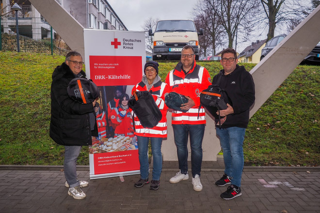 Zwei Betriebsratsvertreter der Stadtwerke Bochum übergeben Schlafsäcke an zwei Ehrenamtliche der Kältehilfe.